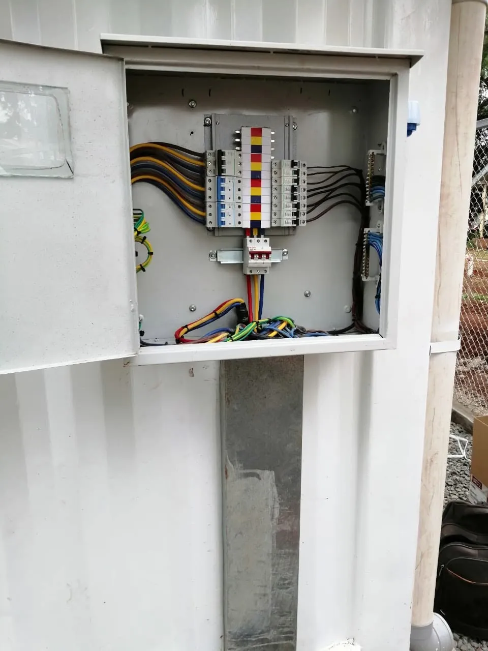 Wall-mounted distribution board with colour-coded phase wiring