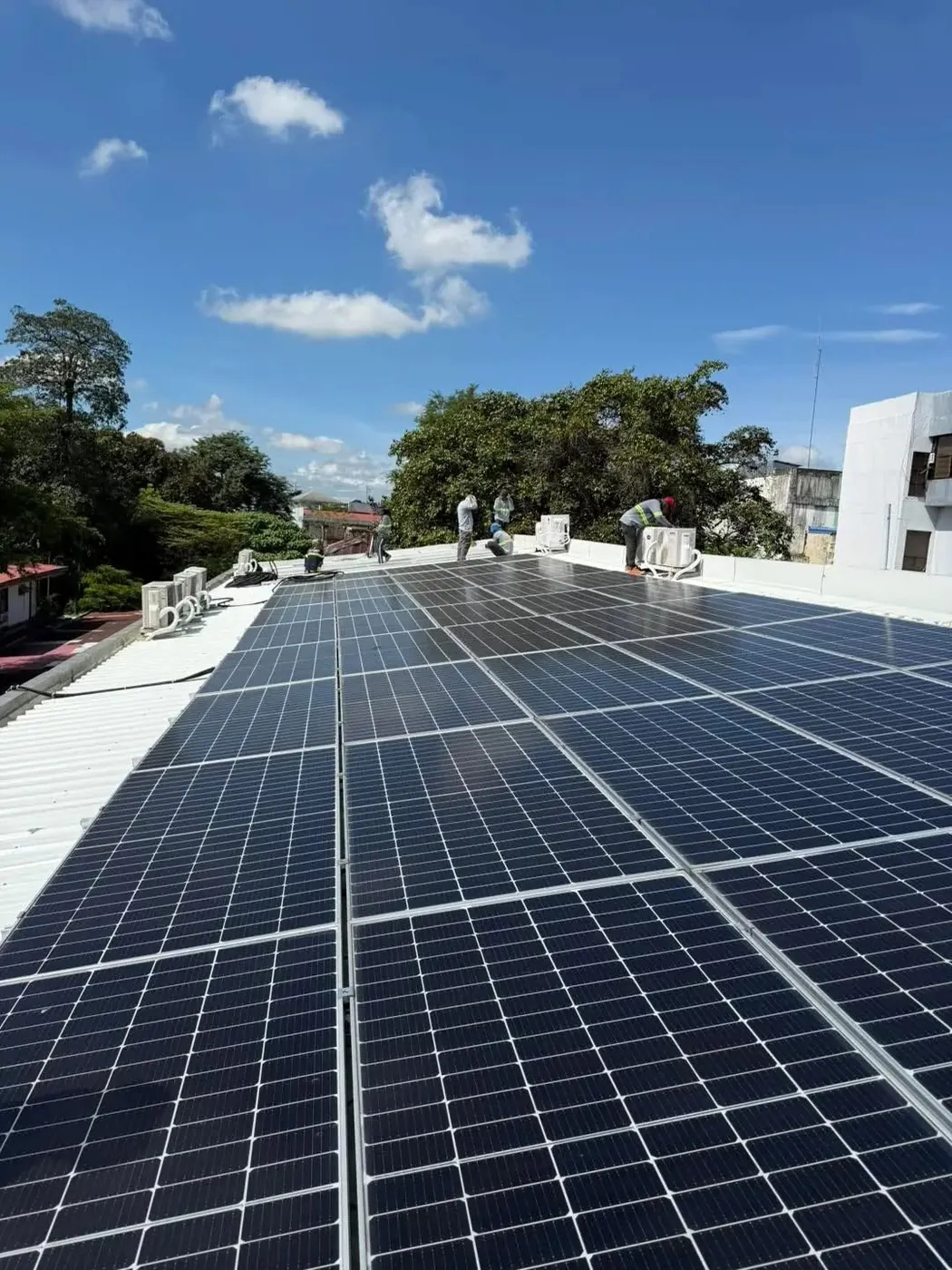 Crew installing a rooftop solar array on a flat roof