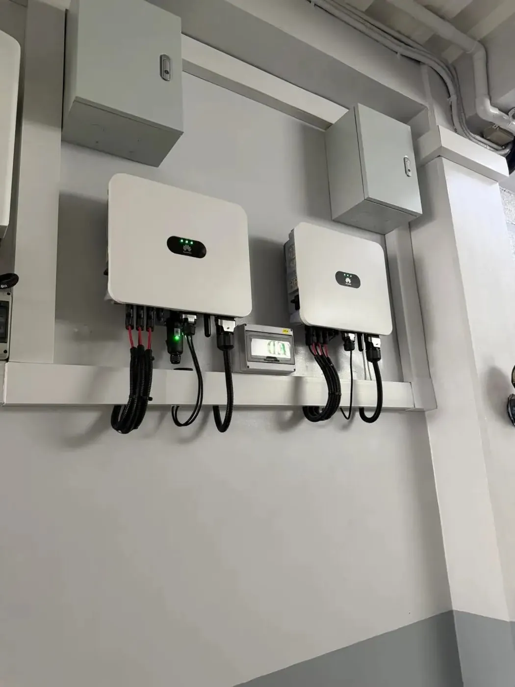 Two wall-mounted solar inverters with cable management